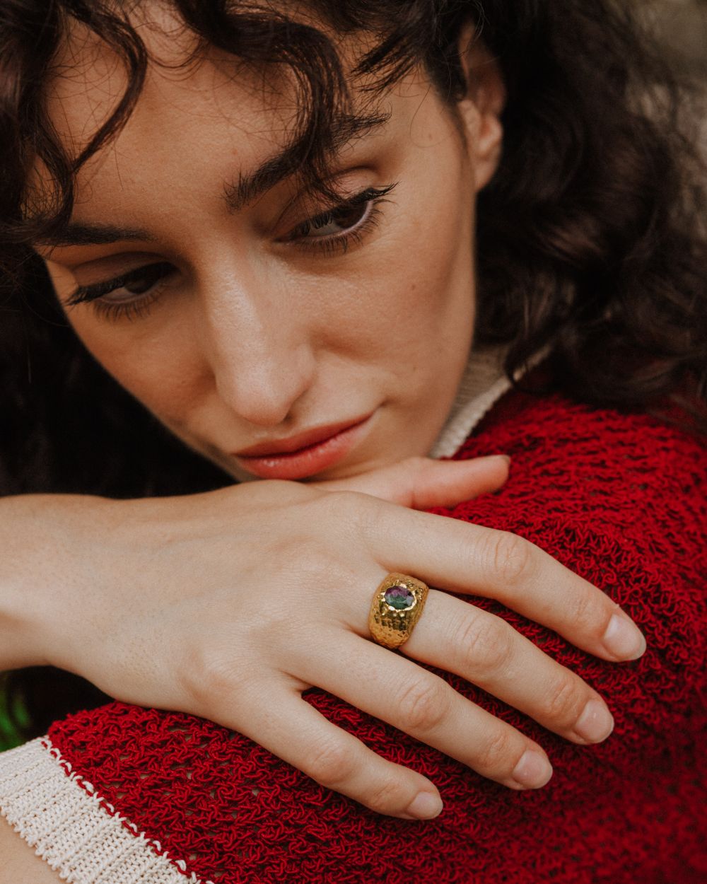 Primer plano de la modelo con el anillo bañado en oro de 18k con piedra semipreciosa Rubí Zoisita de Isla Vurma
