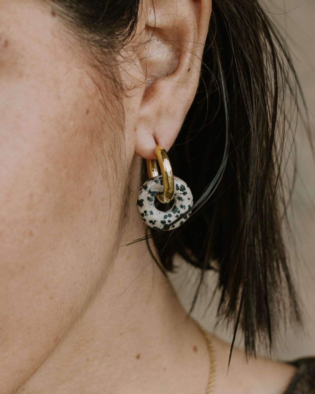 Aros de latón bañados en Oro de 18 quilates con Jaspe Dálmata, que tienen un color negro, marrón y gris