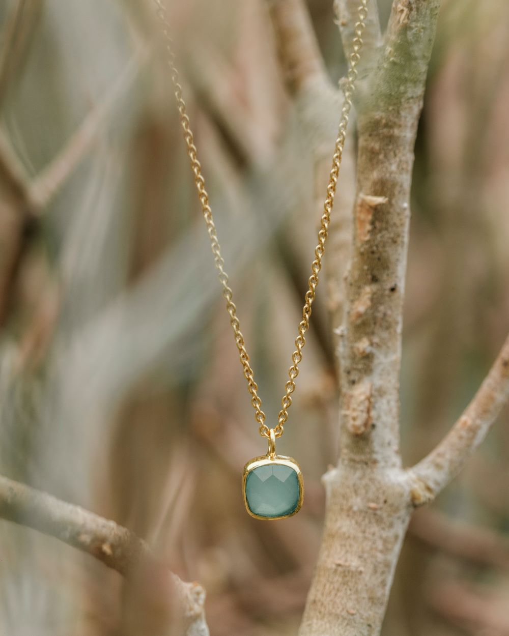 Collar con pieza cuadrada disponible en Aqua Calcedonia, en un fondo natural de Isla Vurma