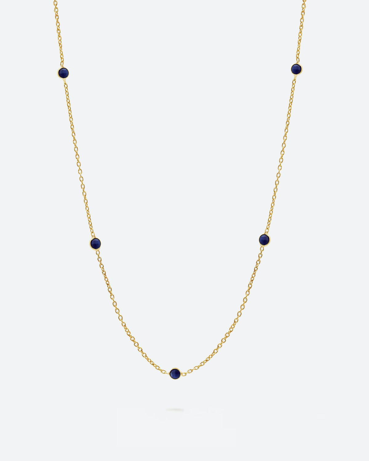 Collar bañado en oro de 18k con piedras de Lapislázuli sobre fondo claro de Isla Vurma