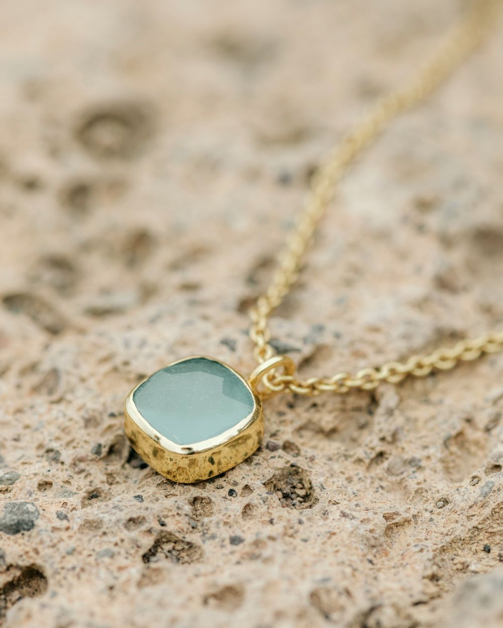 Collar cuadrado con piedra semipreciosa Aqua Calcedonia apoyado en roca natural de Isla Vurma