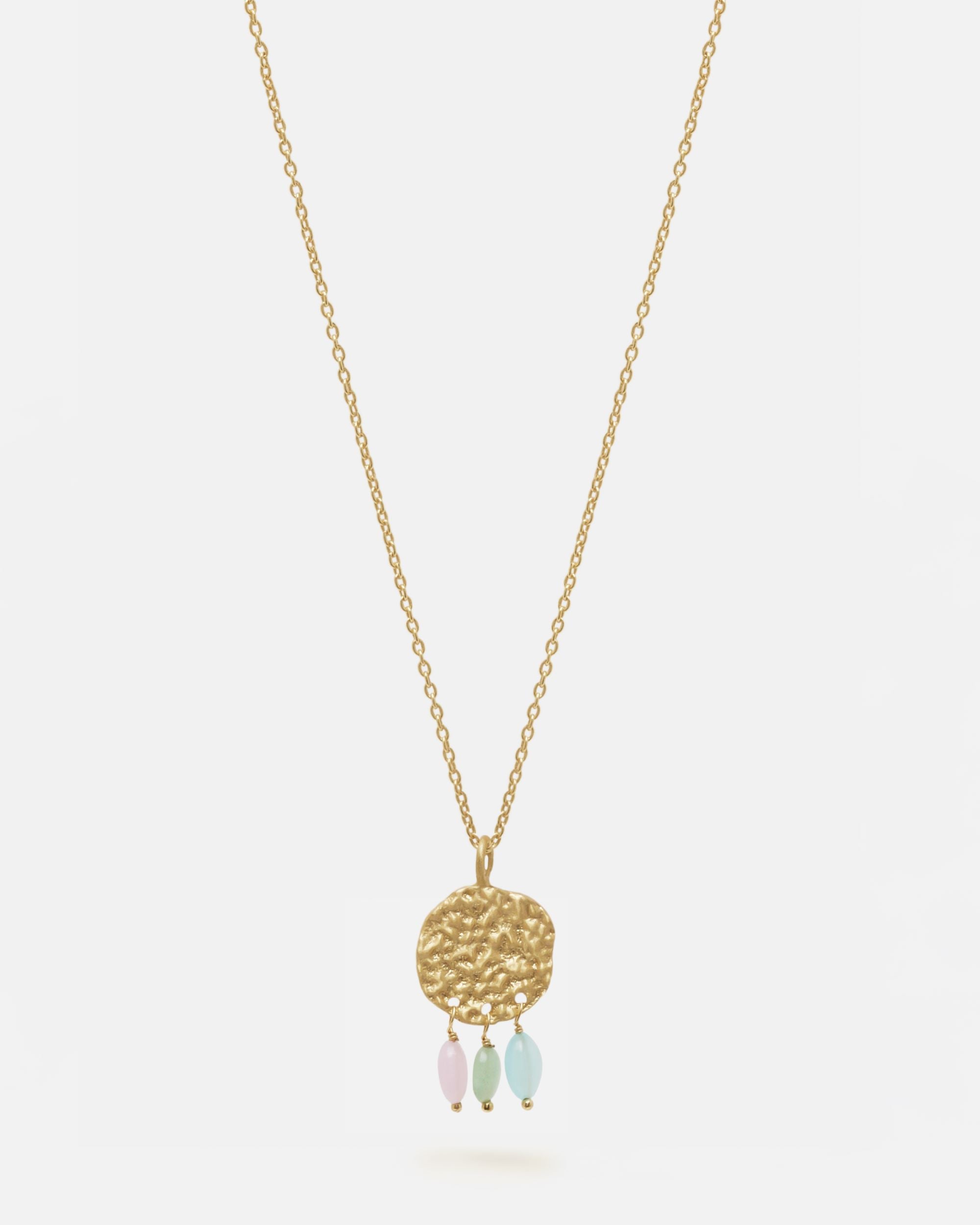 Primer plano del collar bañado en oro de 18 quilates con una pieza circular martillado con tres piedras semipreciosas en forma de gota en Aqua, Cuarzo Melocotón y Aventurina Verde sobre fondo blanco de Isla Vurma