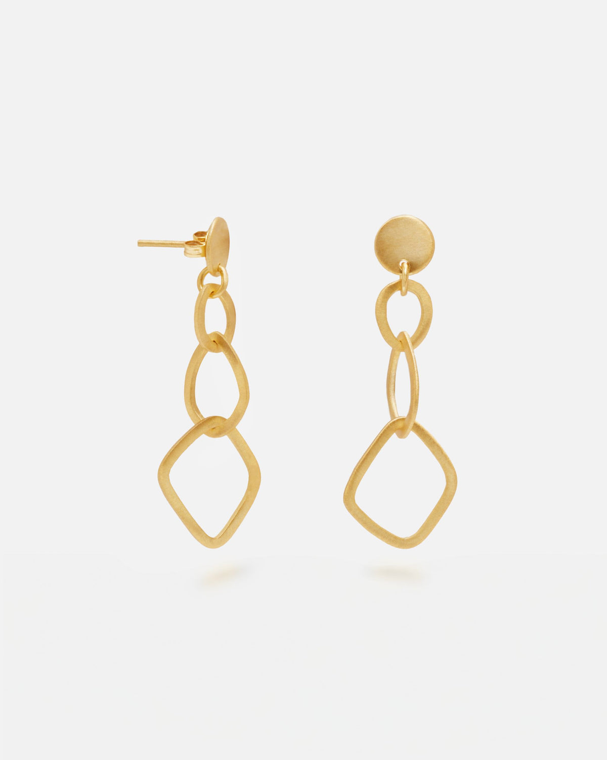 Primer plano de los pendientes geométricos largos bañados en oro de 18k de Isla Vurma