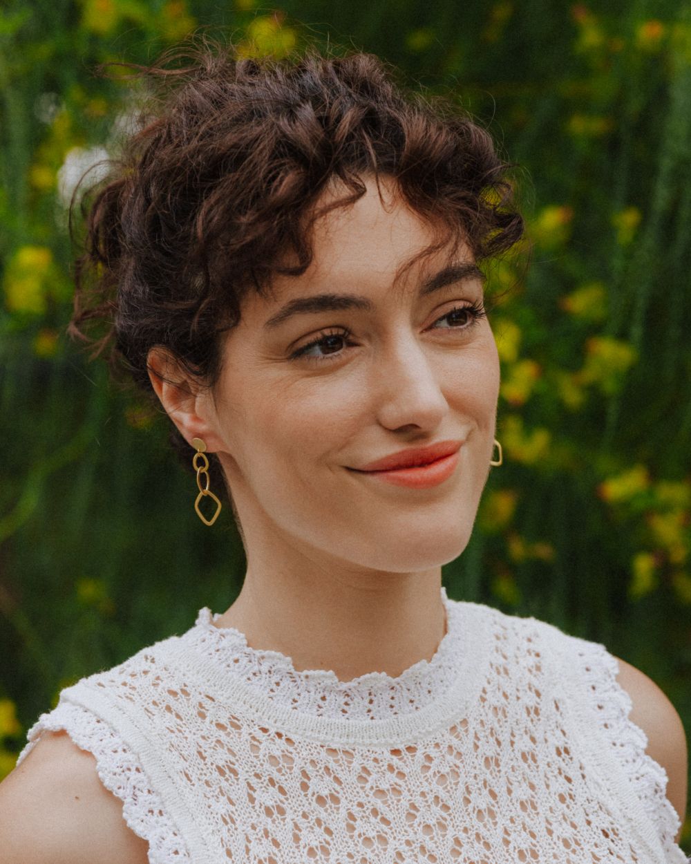 Primer plano de la modelo con los pendientes de formas geométricas largos bañados en oro de 18k de Isla Vurma