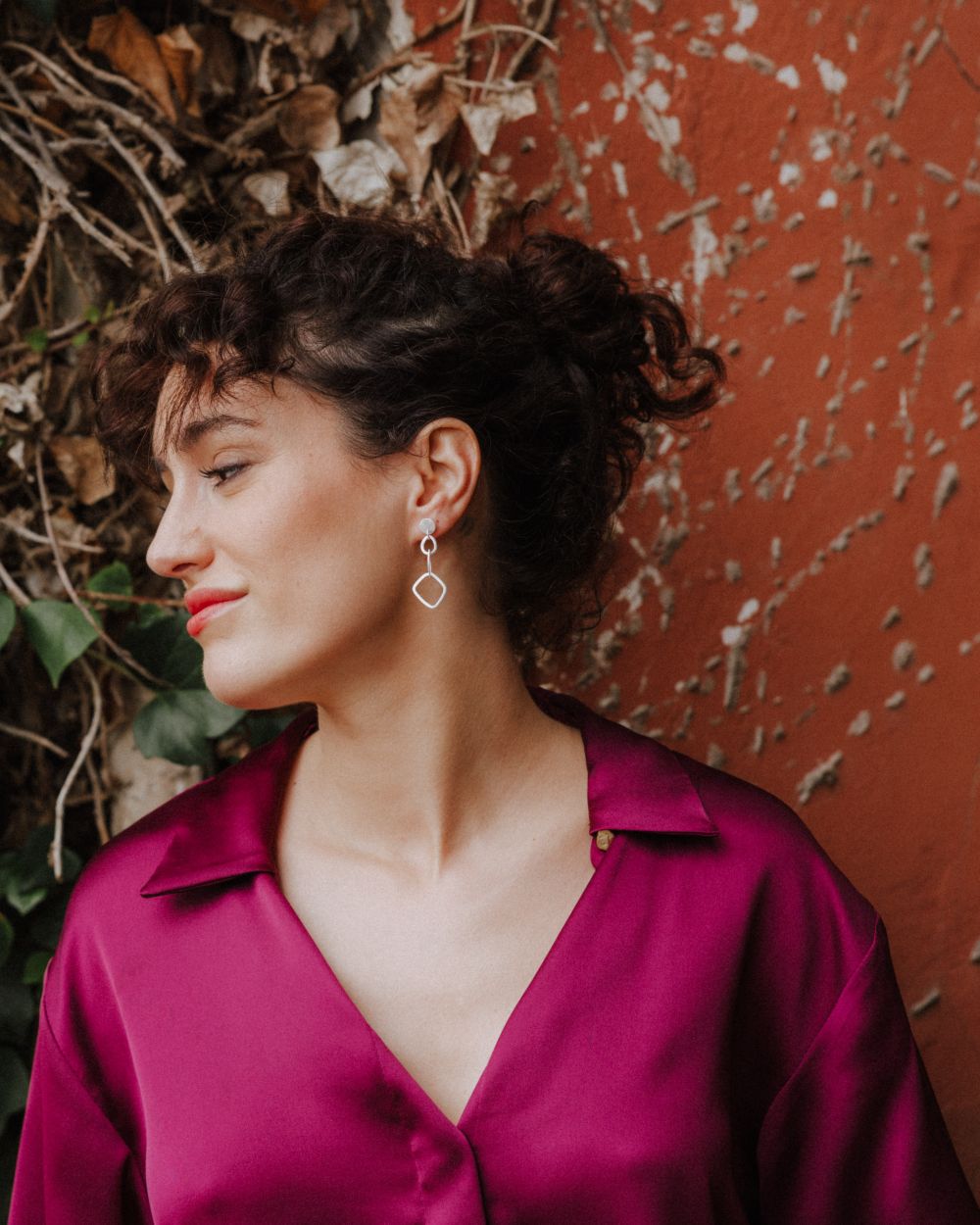 Primer plano de la modelo con los pendientes de formas geométricas largos bañados en plata 925 de Isla Vurma