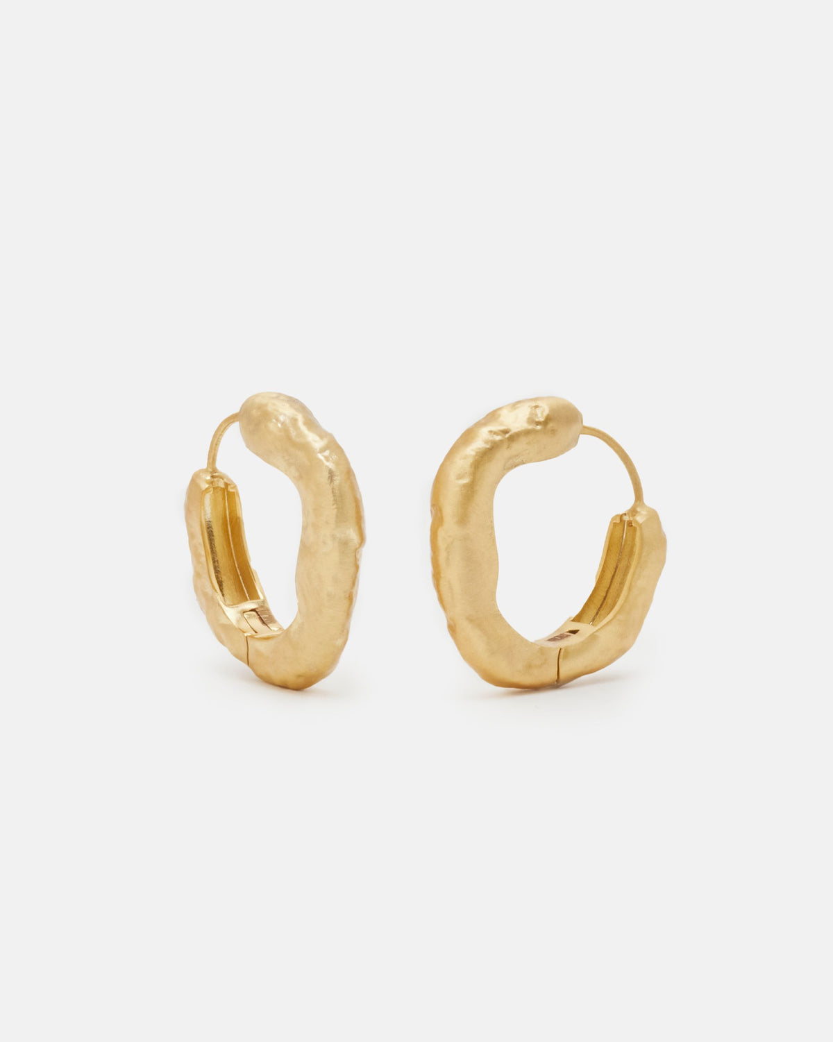 Primer plano de los pendientes gruesos circulares irregulares bañados en oro de 18k de Isla Vurma