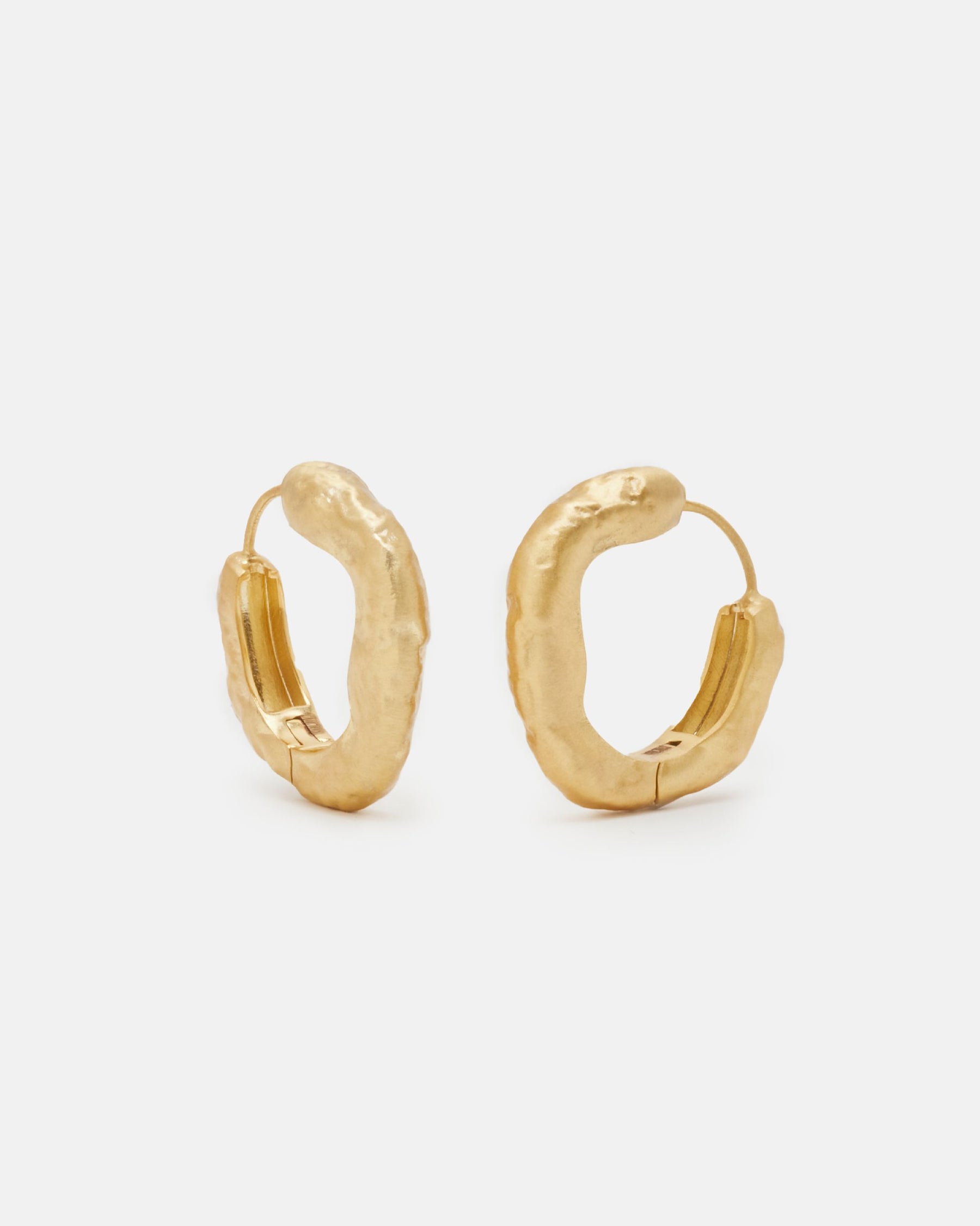 Primer plano de los pendientes gruesos circulares irregulares bañados en oro de 18k de Isla Vurma