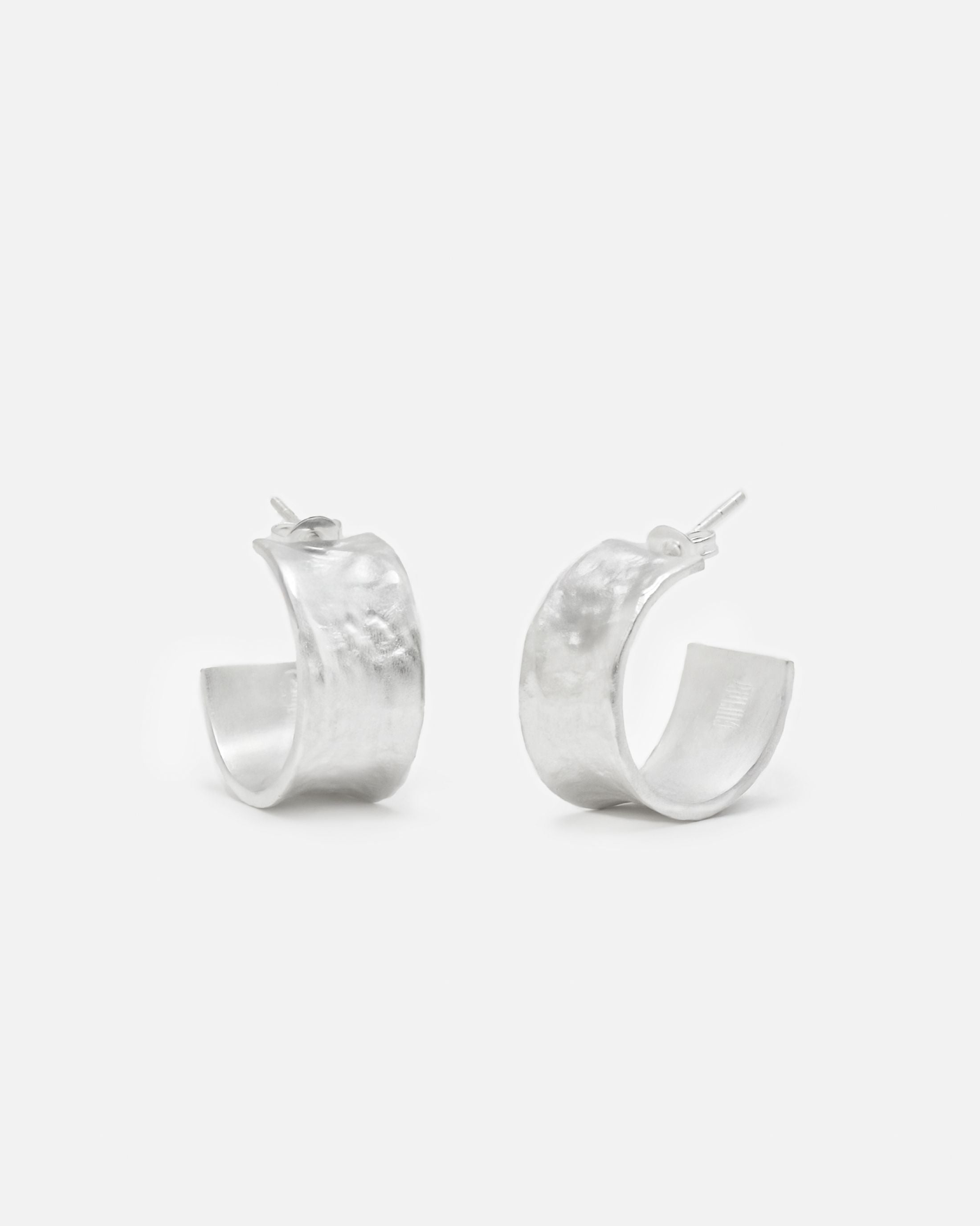 Primer plano de los pendientes bañados en plata 925 ondulados abiertos y cierre mariposa de Isla Vurma