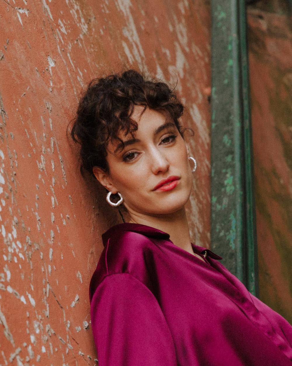 Modelo mirando al frente llevando los pendientes gruesos circulares irregulares bañados en plata 925 de Isla Vurma