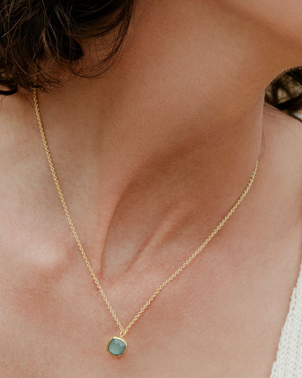 Modelo, en primer plano, con el collar bañado en oro de 18 quilates, disponible en piedra semipreciosa Aventurina Verde de Isla Vurma