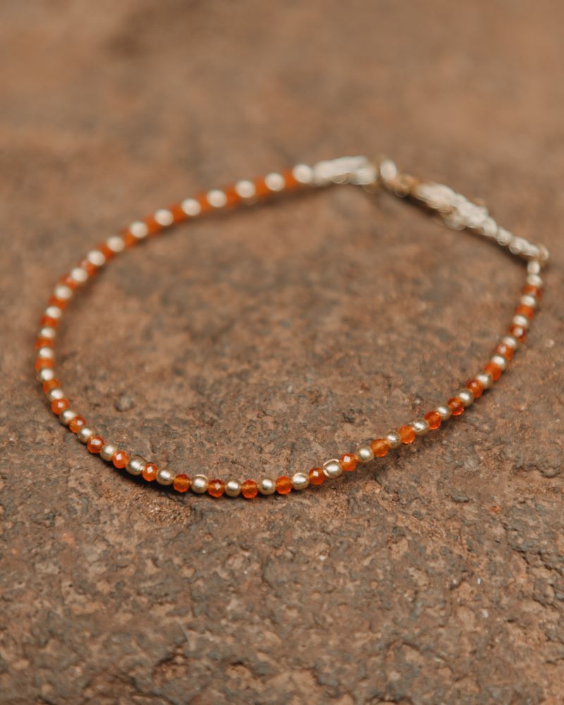 Primer plano una pulsera con cuentas facetadas de piedra semipreciosa en Cornalina y bañadas en Oro de 18 quilates