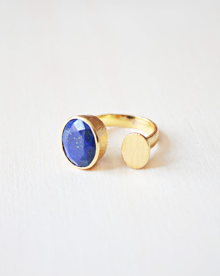 Primer plano delanillo abierto bañado en oro de 18k con piedra semipreciosa en forma circular en Lapislázuli de Isla Vurma