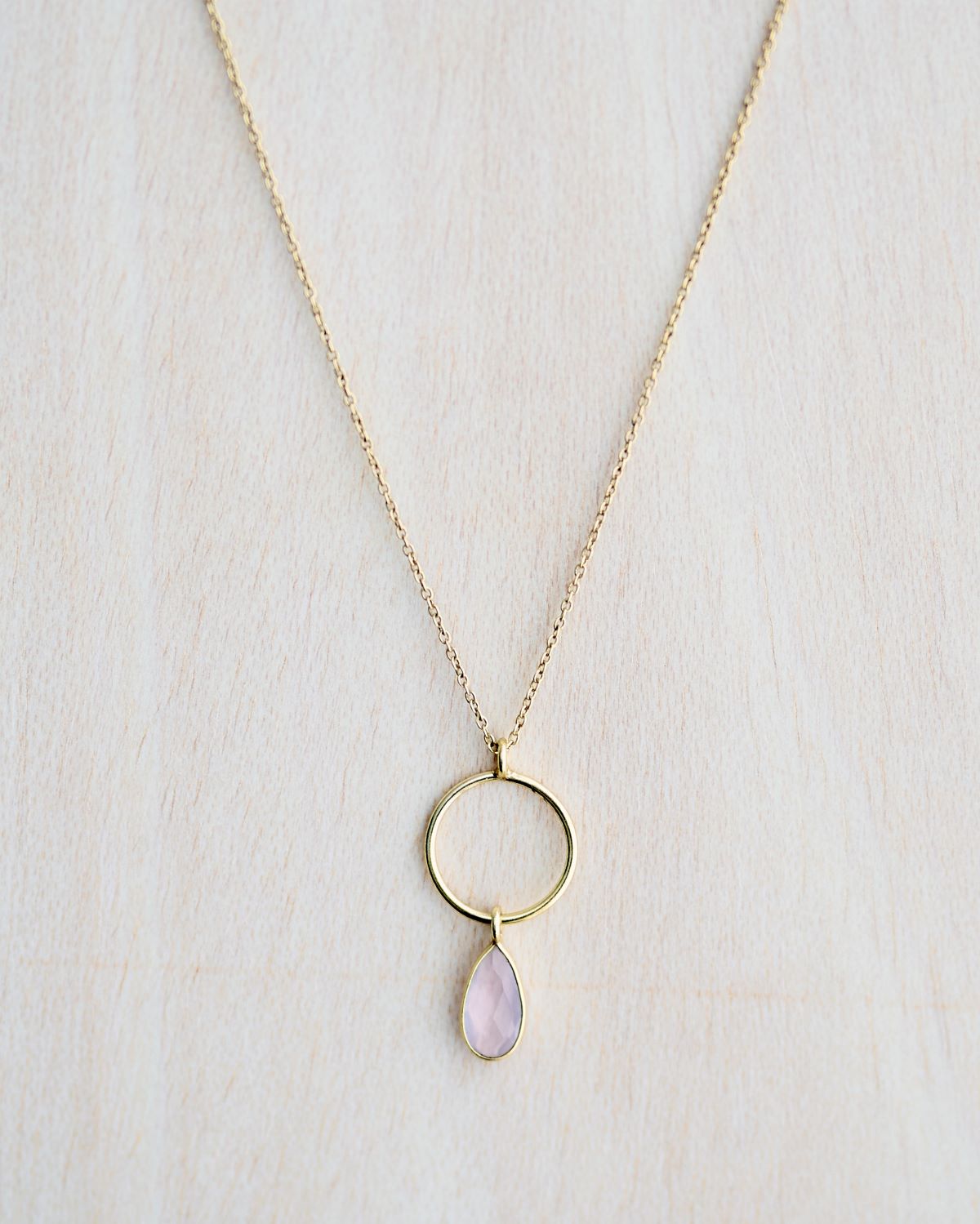 Primer plano del collar bañado en oro, con piedra semipreciosa en Quarzo Rosa en forma de gota de Isla Vurma