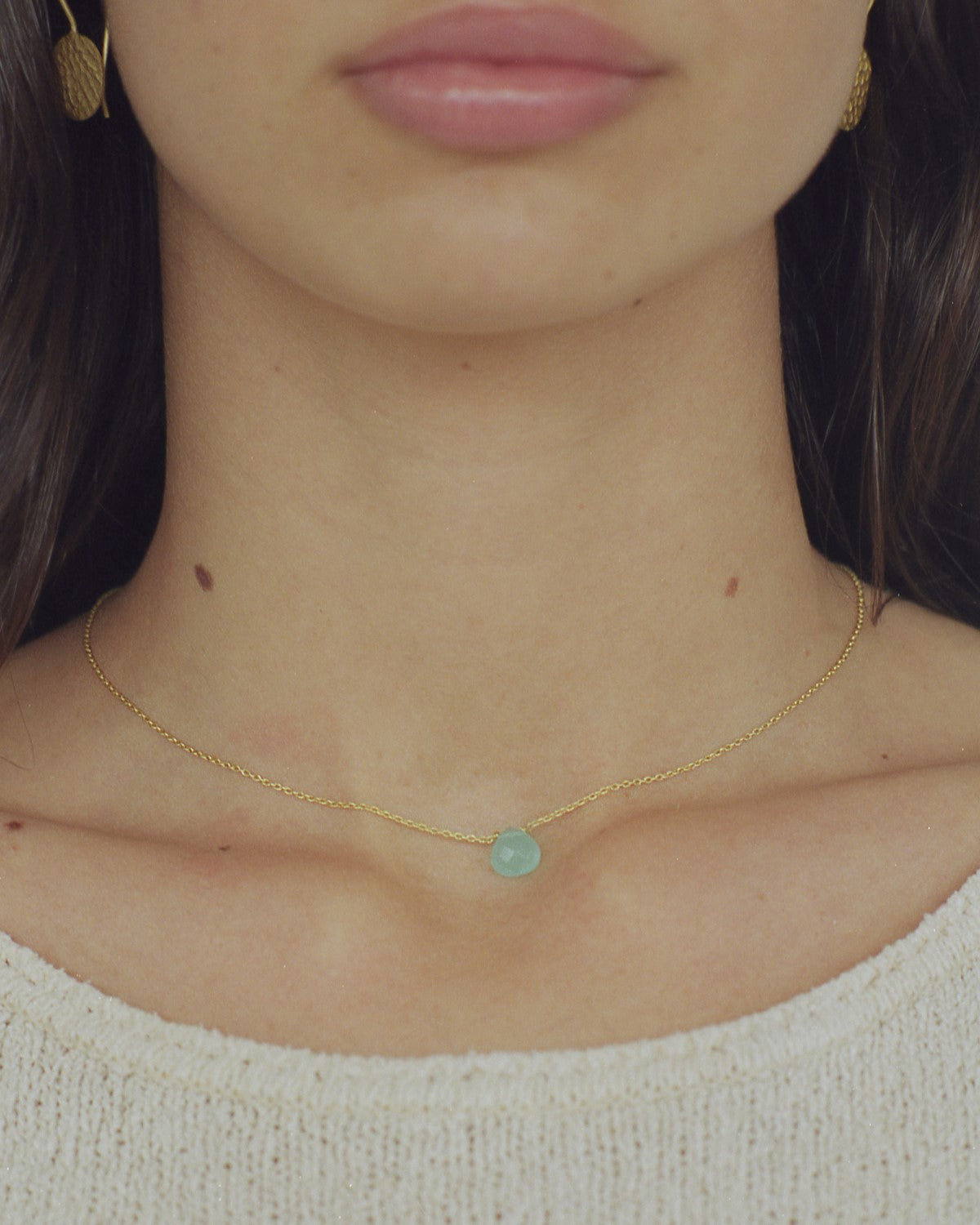 Modelo con collar bañado en oro de 18 quilates con piedra tallada en Aqua Calcedonia de Isla Vurma