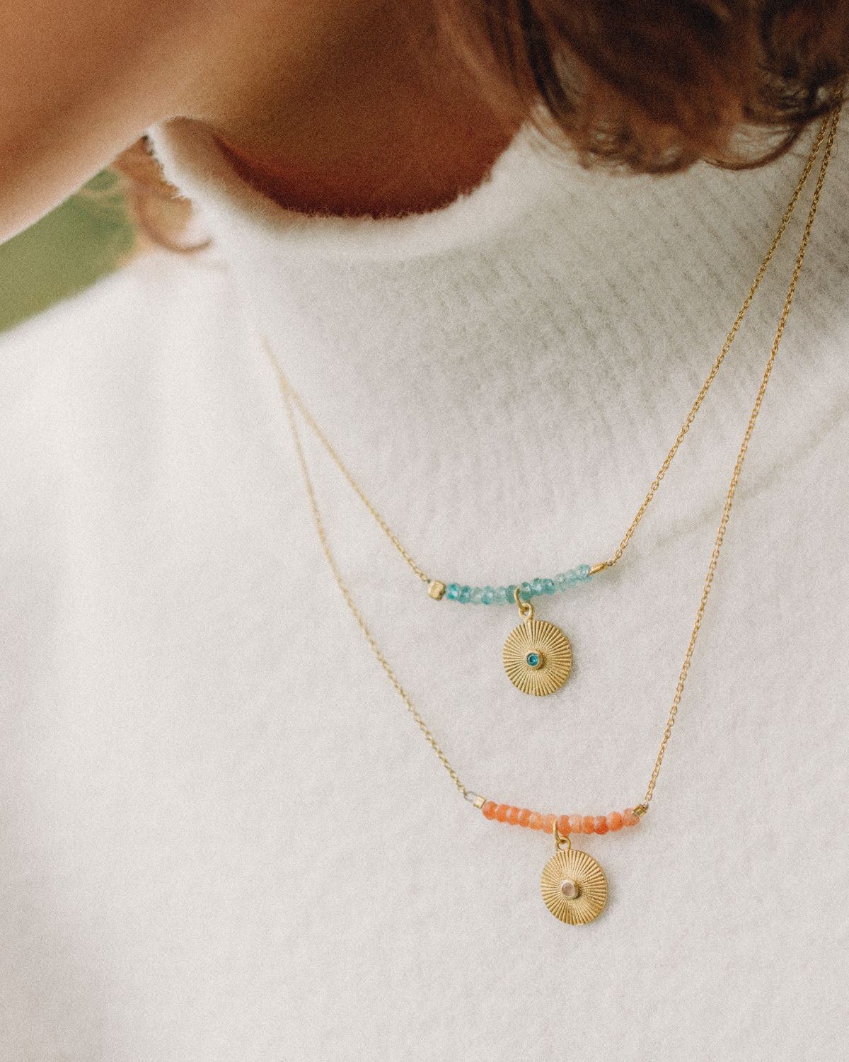 Modelo con collares de calcedonia y piedra de luna melocotón de Isla Vurma