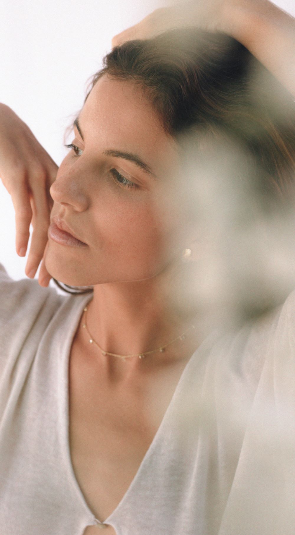 Imagen con sombra blanca y modelo con un conjunto de collar de piedra semipreciosa Turmalina y pendientes de color dorado y plateado de Isla Vurma