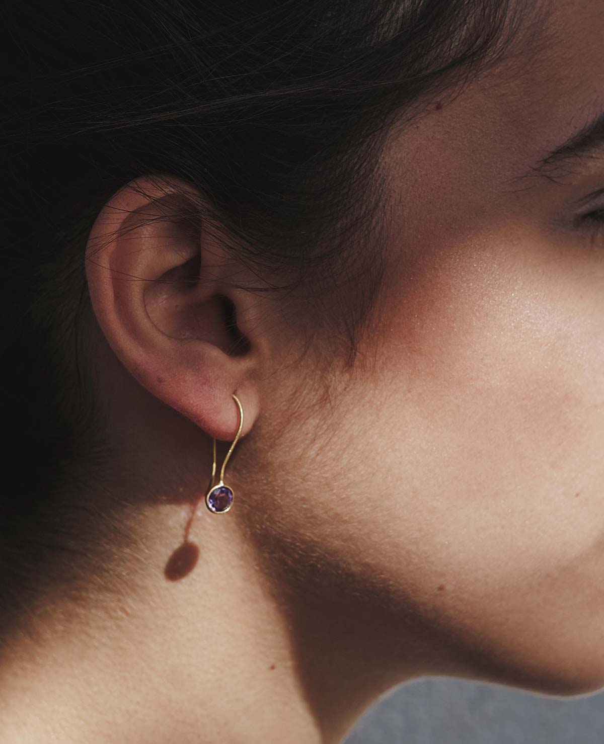 Modelo con pendientes elaborados con amatista natural, de color violeta y con cierre en forma de gancho
