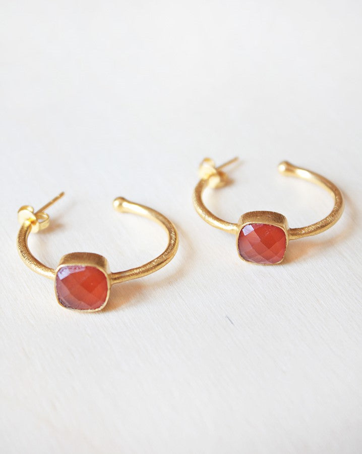 Primer plano de los pendientes bañados en Oro de 18 quilates con piedra semipreciosa cuadrada en Cornalina de Isla Vurma