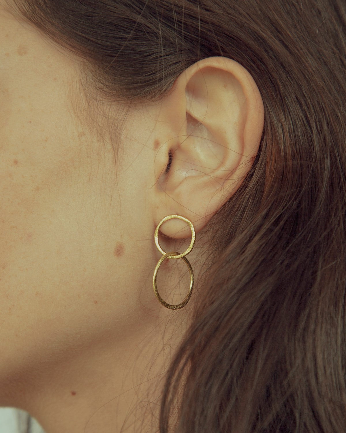 Primer plano de la modelo con los pendientes bañados en oro de 18k compuesto por dos piezas circulares de Isla Vurma