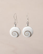 Pendientes artesanales de plata de ley con Ojo de Santa Lucía. Concha formada por espiral natural y montura de plata de ley sobre fondo neutro