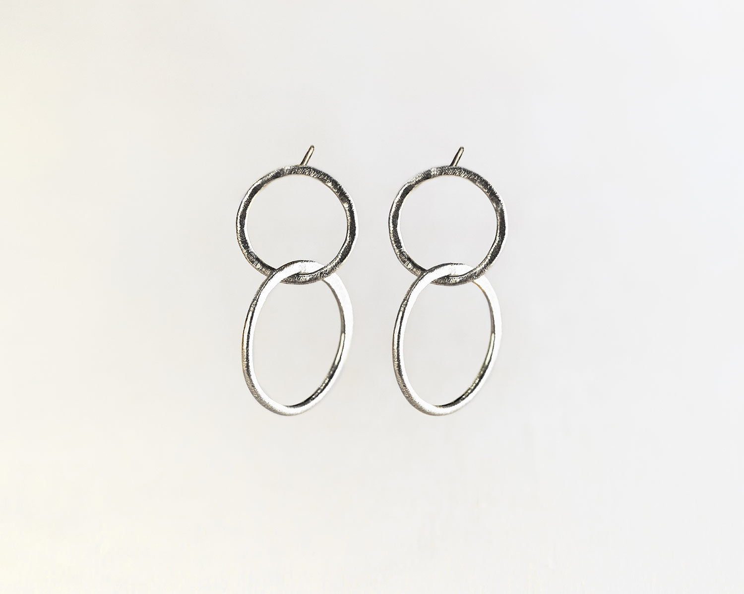 Primer plano de los pendientes plateados compuestos por dos piezas circulares de Isla Vurma