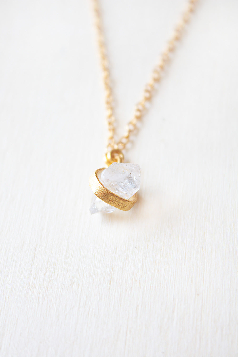 Primer plano de la piedra semipreciosa Piedra de Luna, sujetada por una pequeña pieza rectangular dorada de Isla Vurma