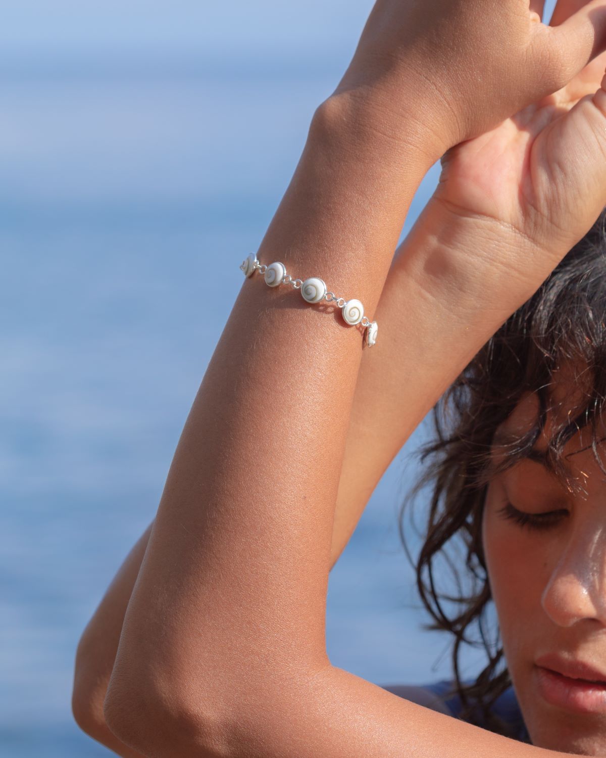 Primer plano del brazo de la modelo luciendo la pulsera en Plata de Ley 925 compuesta por 8 piedras pulidas de Santa Lucía de 10mm y cierre ajustable de gancho