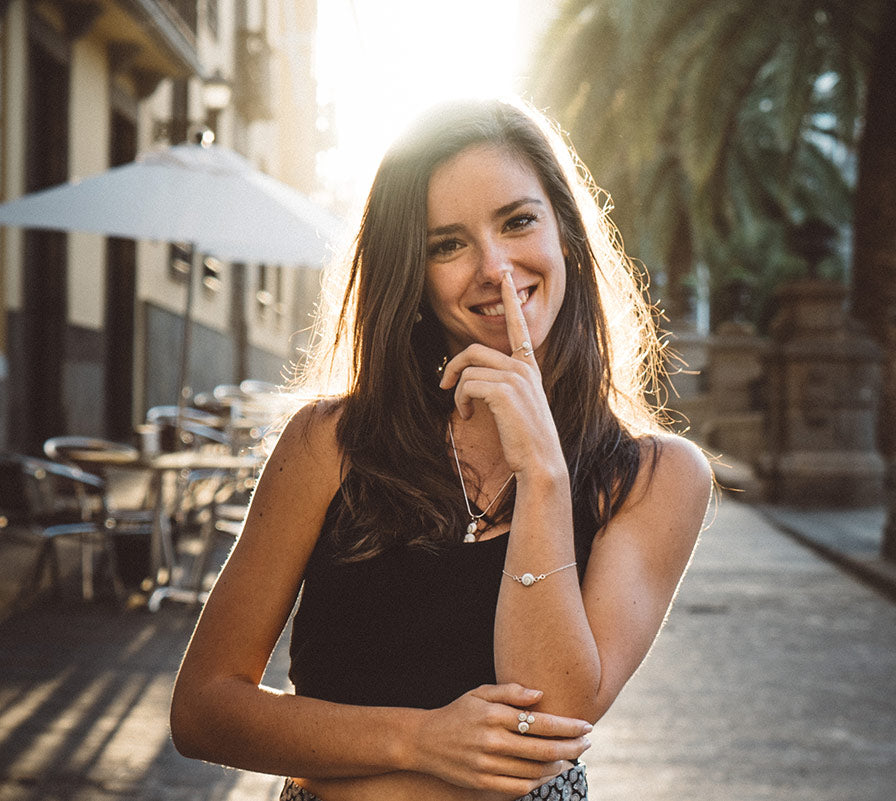 Modelo sonriendo al aire libre luciendo pulsera de plata con piedra natural de Santa Lucía