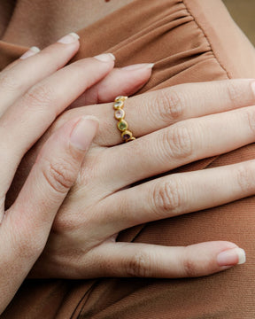 Primer plano de la mano de la modelo con el anillo bañado en oro de 18 quilates con piedras semipreciosas en Aqua Calcedonia, Cuarzo Rosa, Jade, Amatista y Aventurina Verde de Isla Vurma