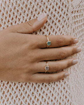 Mano de la modelo con el anillo bañado en oro con piedra central cuadrada en Aventurina Verde y Cuarzo Rosa de Isla Vurma