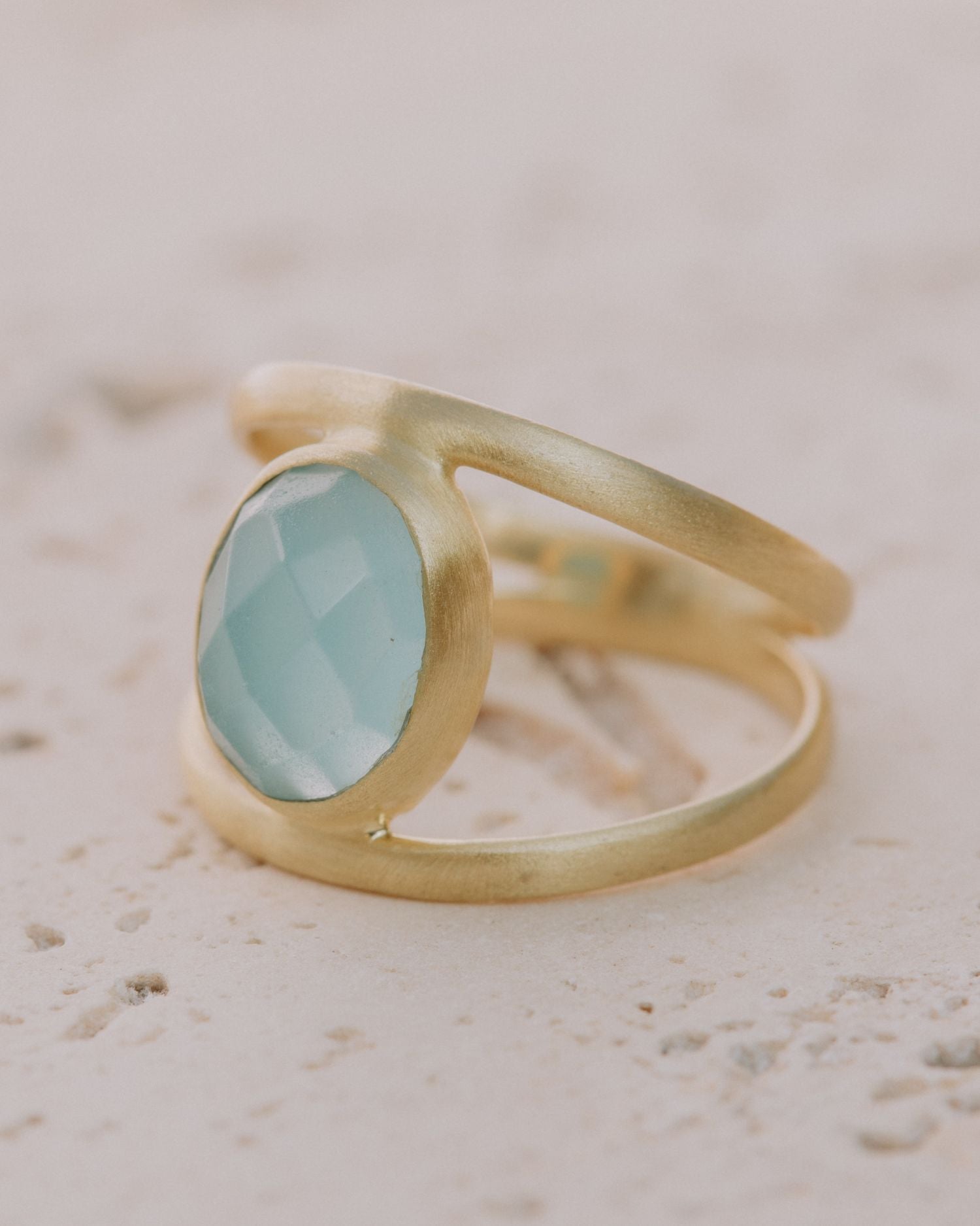 Primer plano del anillo bañado en Oro de 18k con piedra semipreciosa Aqua Calcedonia tallada en forma ovalada