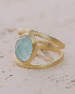 Primer plano del anillo bañado en Oro de 18k con piedra semipreciosa Aqua Calcedonia tallada en forma ovalada