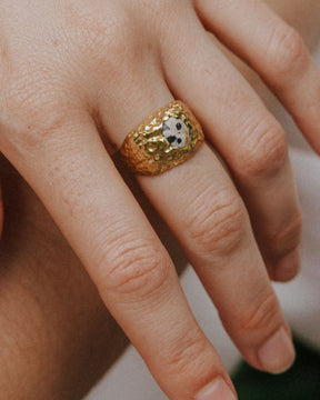 Primer plano de la mano de la modelo con el anillo bañado en oro de 18k con piedra semipreciosa Jaspe Dálmata de Isla Vurma