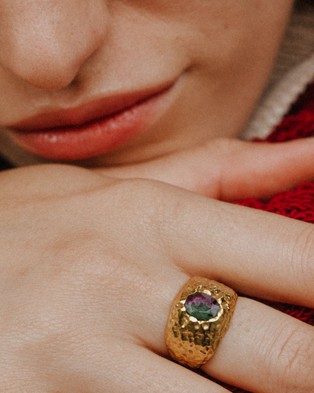 Primer plano de la mano de la modelo con el anillo bañado en oro de 18k con piedra semipreciosa Rubí Zoisita de Isla Vurma