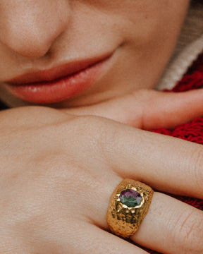 Primer plano de la mano de la modelo con el anillo bañado en oro de 18k con piedra semipreciosa Rubí Zoisita de Isla Vurma