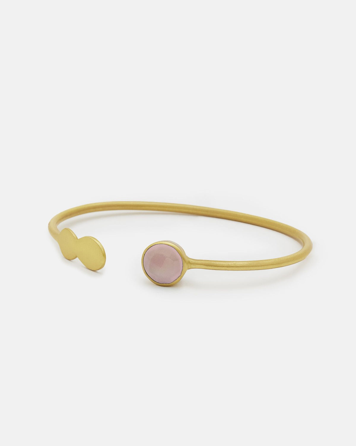 Primer plano del brazalete de latón bañado en oro de 18 quilates con una piedra semipreciosa en Cuarzo Rosa en uno de los extremos