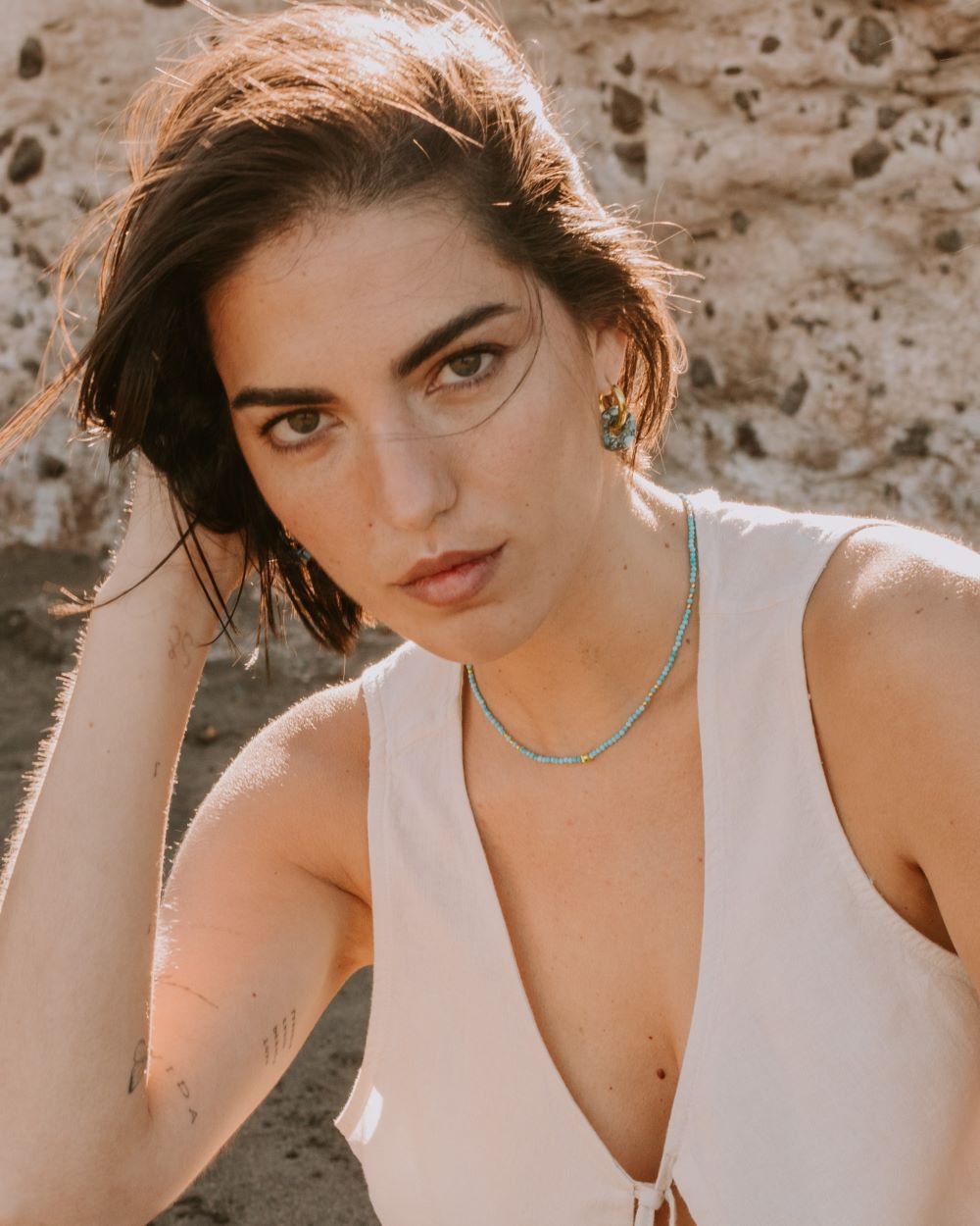 Modelo con collar turquesa bañado en Oro y pendientes color turquesa y negros bañado en Oro 18k