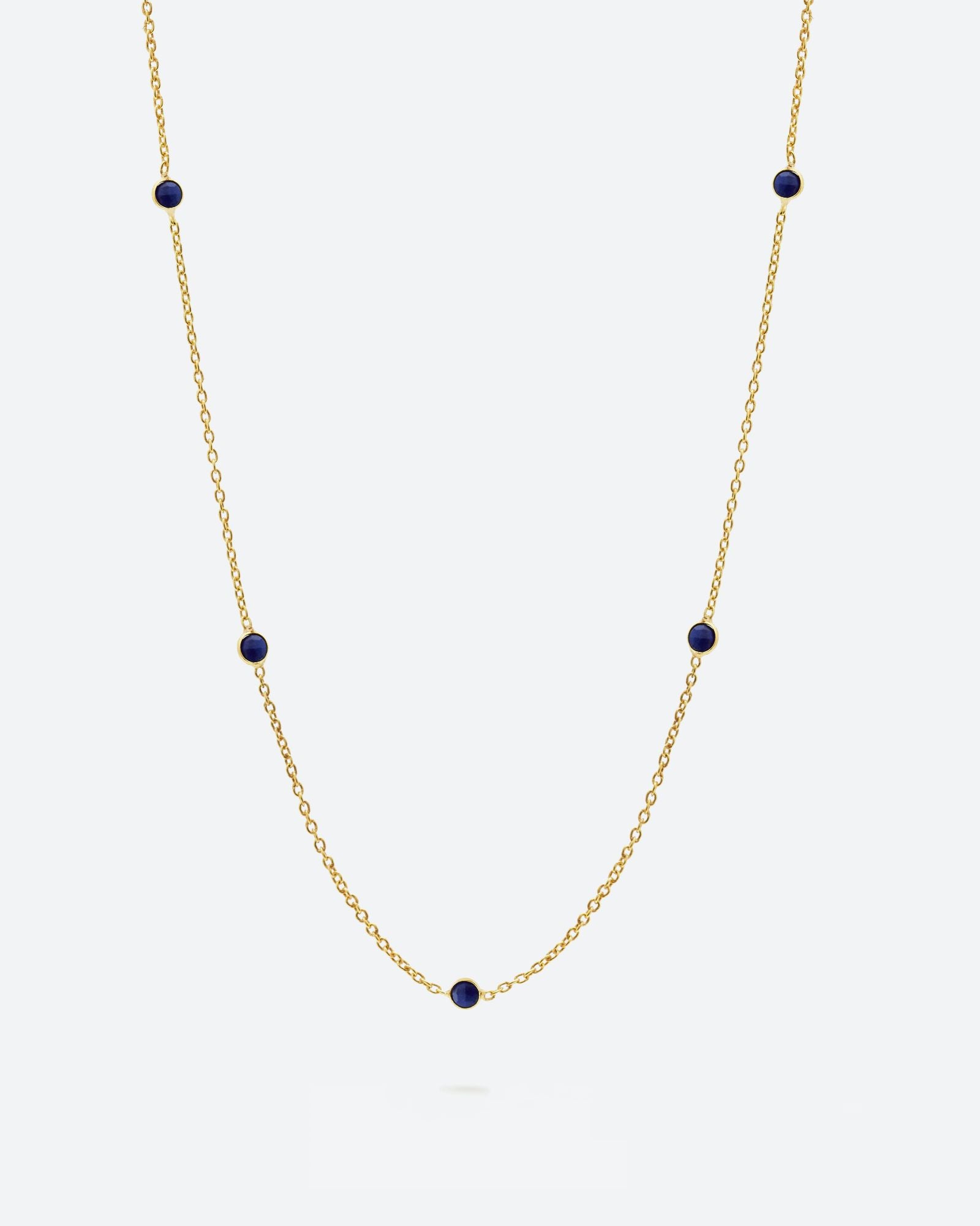 Collar bañado en oro de 18k con piedras de Lapislázuli sobre fondo claro de Isla Vurma 