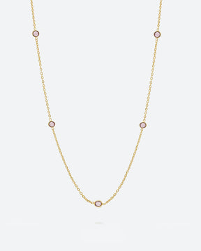 Collar bañado en oro de 18k con piedras de Cuarzo Rosa sobre fondo claro de Isla Vurma 
