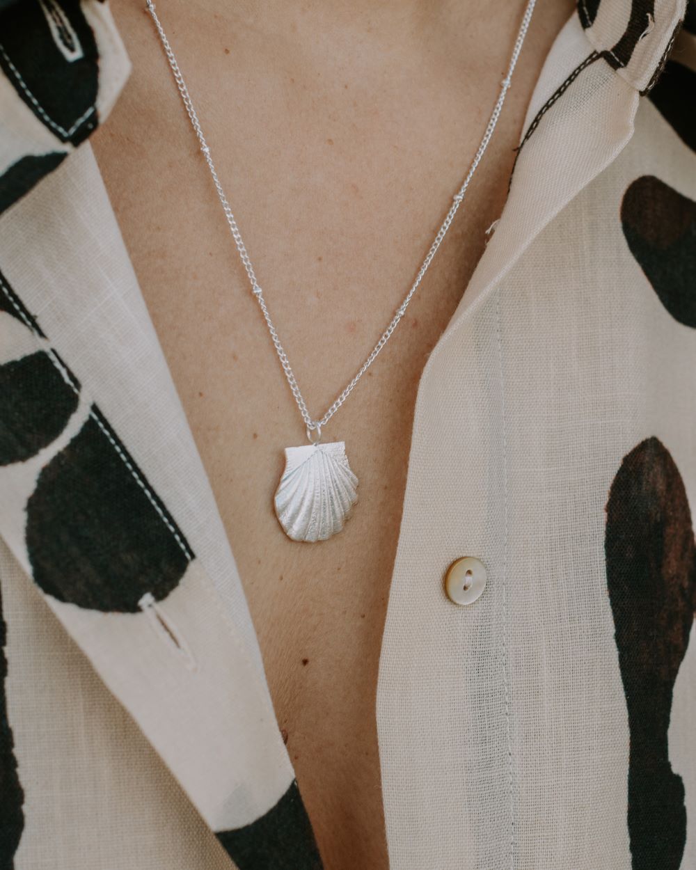 Collar de Isla Vurma en forma de concha con cadena plateada que contiene pequeñas cuentas.