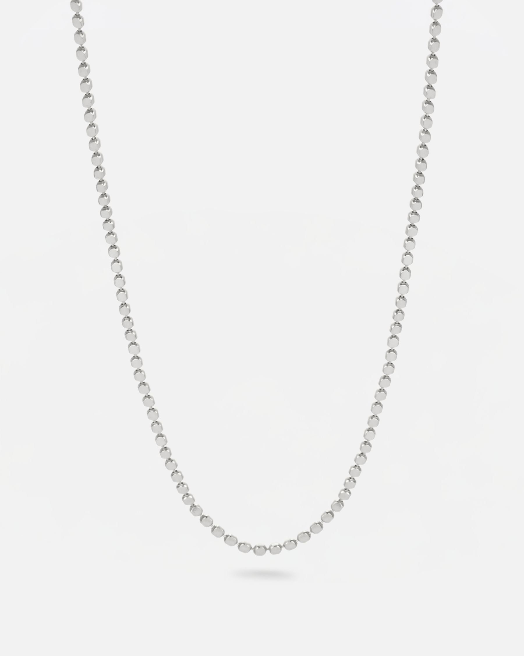 Collar de cadena fina bañado en plata de ley con pequeñas piezas rectangulares unidas.