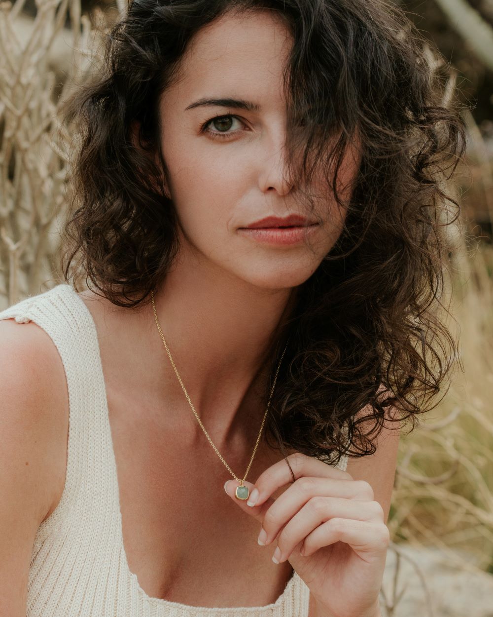 Medio plano de la modelo con collar bañado en oro de 18 quilates con pieza cuadrada de piedra semipreciosa Aventurina Verde de Isla Vurma