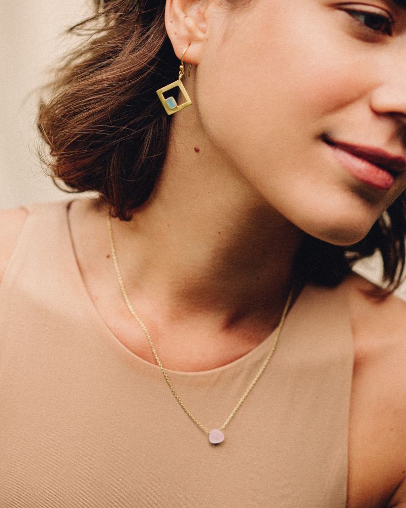 Modelo con collar bañado en oro de 18 quilates con piedra tallada en Cuarzo Rosa de Isla Vurma