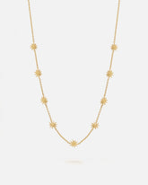 Collar dorado de cadena fina decorado con pequeños colgantes en forma de estrella de ocho puntas distribuidos de manera uniforme