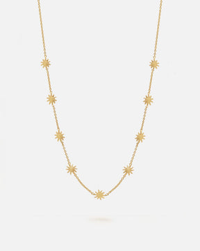 Collar dorado de cadena fina decorado con pequeños colgantes en forma de estrella de ocho puntas distribuidos de manera uniforme