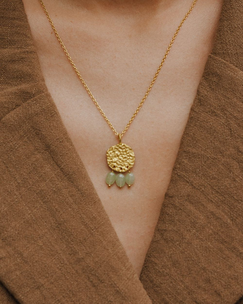 Collar Lirio en oro de 18K con piedras en forma de gota en Aventurina Verde lucido en el cuello de la modelo