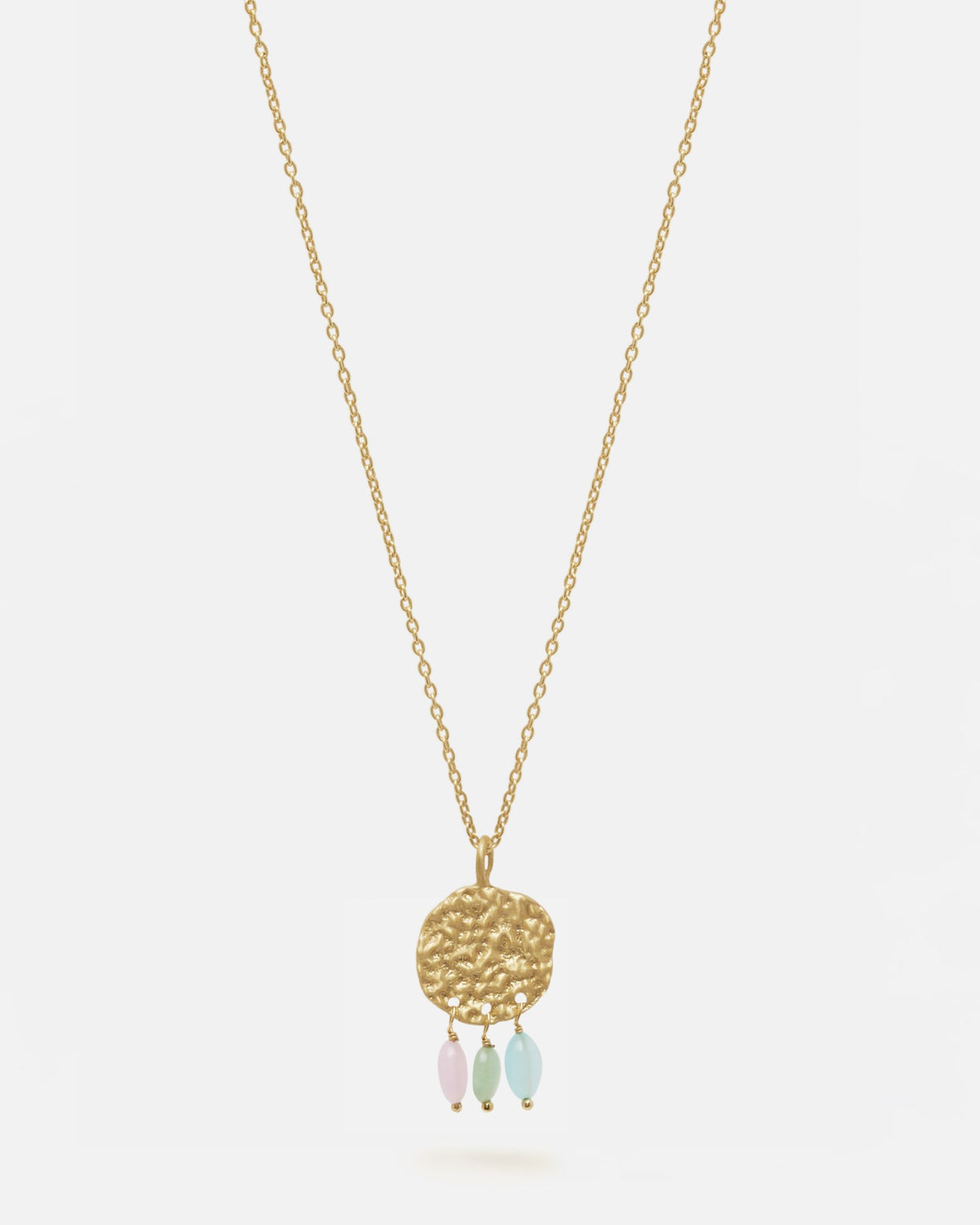 Primer plano del collar bañado en oro de 18 quilates con una pieza circular martillado con tres piedras semipreciosas en forma de gota en Aqua, Cuarzo Melocotón y Aventurina Verde sobre fondo blanco de Isla Vurma