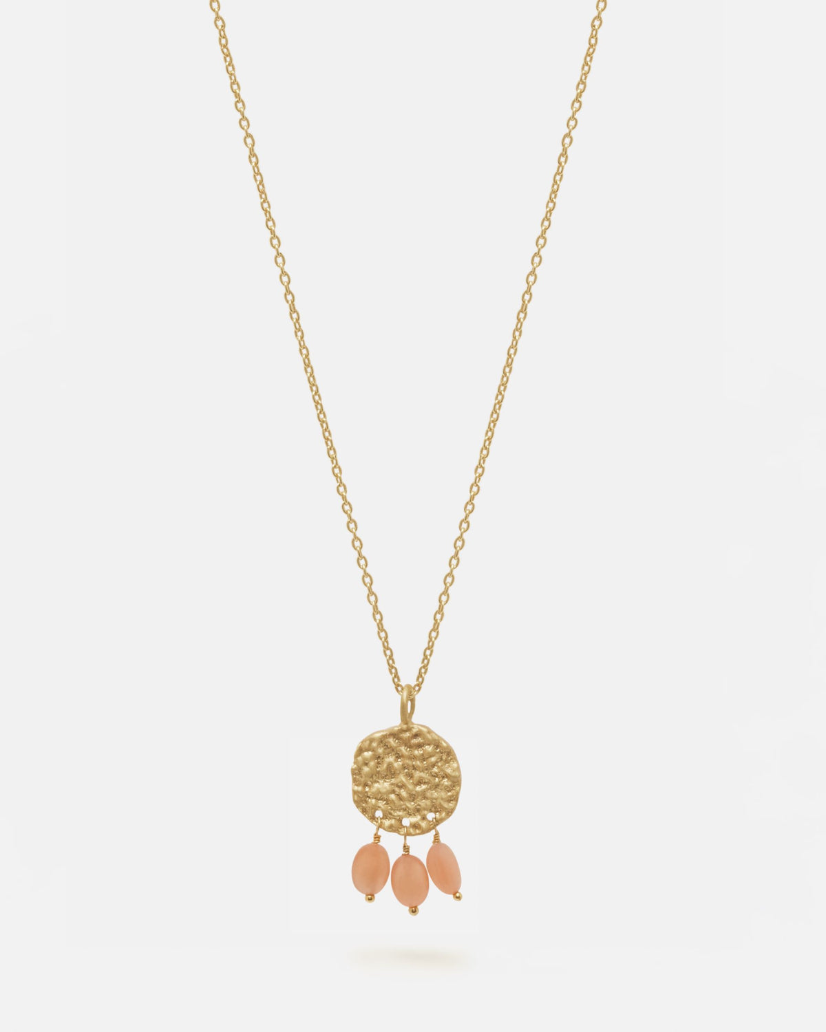 Primer plano del collar bañado en oro de 18 quilates con una pieza circular martillado con tres piedras semipreciosas en forma de gota en Cuarzo Melocotón sobre fondo blanco de Isla Vurma