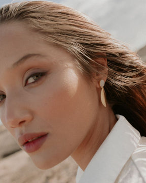 Pendientes artesanales con piedra luna y forma orgánica dorada - pendientes sostenibles de Isla Vurma, elegantes y minimalistas para un look natural y sofisticado