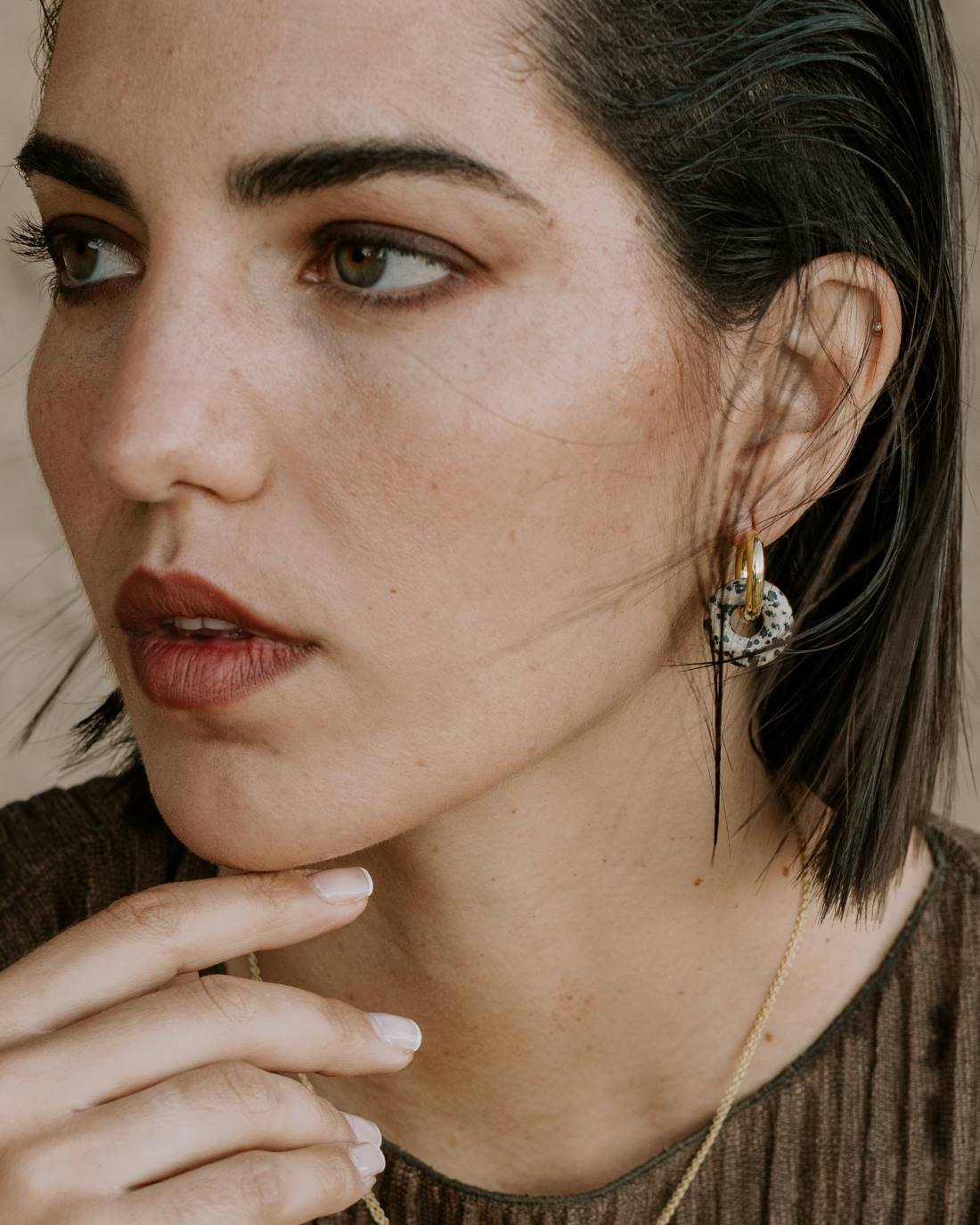 Modelo con aro dorado acabado en Oro de 18 quilates y con una piedra natural pulida denominada Jaspe Dálmata